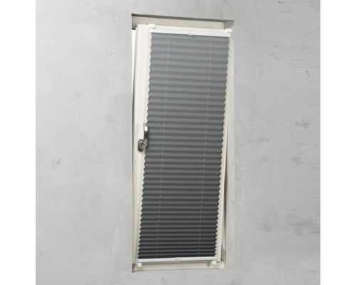 Grå plisségardin på fönstret för skuggning