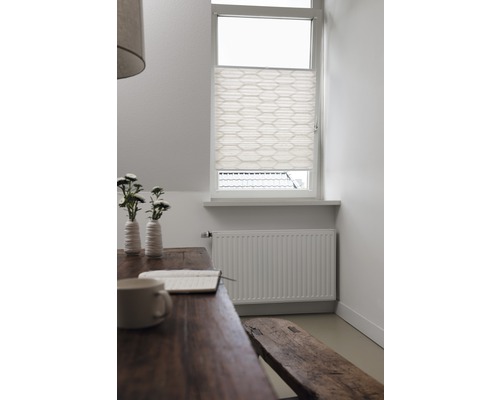 Ljust rum med trämöbler, element och plisségardin i fönstret