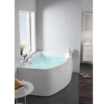 Badrum med hörnbadkar, tvättställ och fönster för en ljus atmosfär