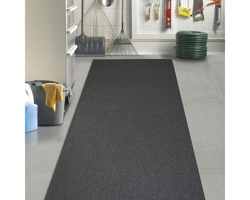 Svart gummimatta i ett garage med trädgårdsredskap