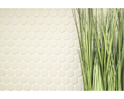 Närbild av runda mosaikplattor bredvid konstgräs