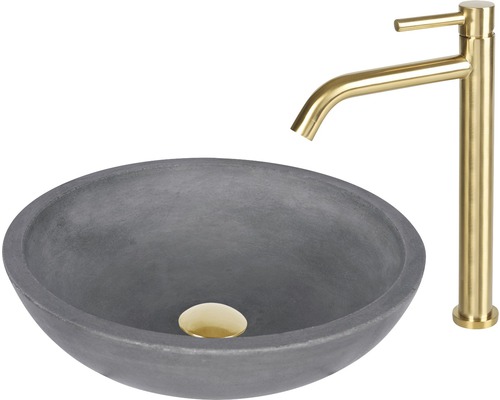 Grått tvättställ i betong med guldfärgad armatur