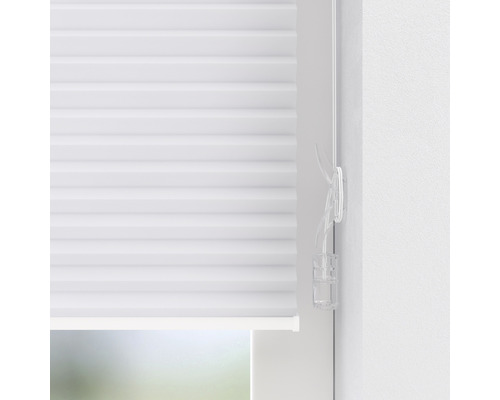 Plisségardin med manöverelement på fönstret