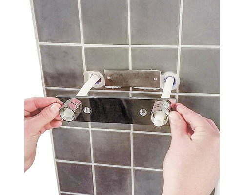 Installation av en armatur på en kakelvägg i badrummet.