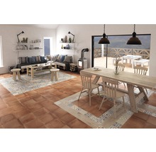 Vardagsrum med sittgrupp, bord och vedeldad kamin på golvplattor