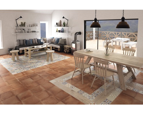 Vardagsrum med sittgrupp, bord och vedeldad kamin på golvplattor