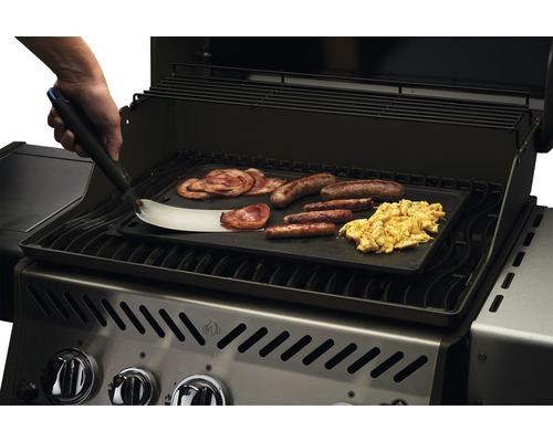 Grill med stekplatta, frukostingredienser och stekspade