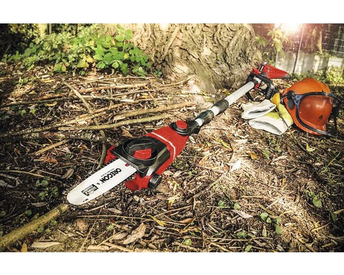 Batteridriven motorsåg med skyddsutrustning i trädgården