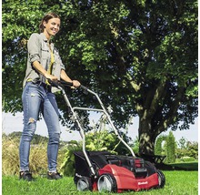 En kvinna använder en Einhell gräsmattluftare på en gräsmatta.