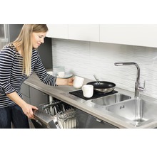 Kvinna ställer in disk i diskmaskinen i ett modernt kök