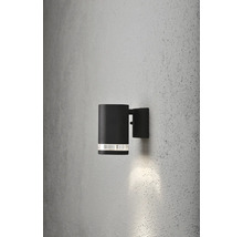Svart utomhusvägglampa med cylindrisk design på en vägg