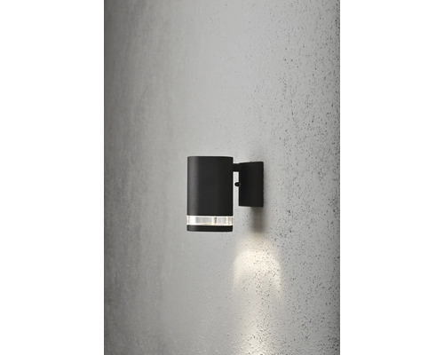Svart utomhusvägglampa med cylindrisk design på en vägg