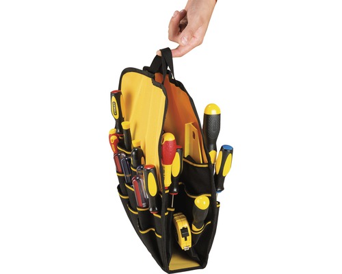 En svart verktygsväska med gult foder, fylld med diverse skruvmejslar och ett måttband, hålls av en hand.