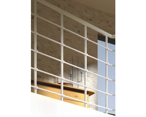 Balkongräcke av metall framför en tegelvägg