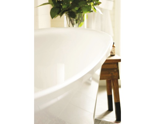 Detaljvy av ett fristående badkar i ett badrum med blommor och en pall