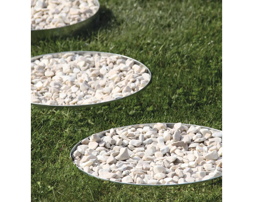 Trädgårdsplattor med vita dekorativa grusstenar i trädgården