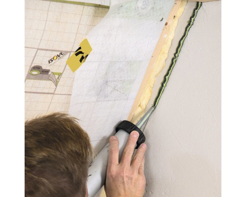 En person tätar en vägg med tätningsmedel.