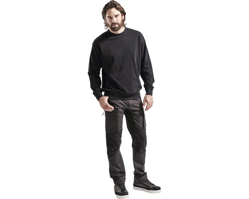 Man som bär arbetskläder bestående av en sweatshirt och arbetsbyxor
