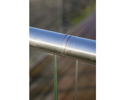 Detaljbild av ett rostfritt stålräcke med glasinsats