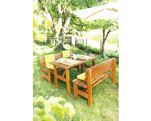 Trädgårdsmöbelset med träbord och bänkar i trädgården