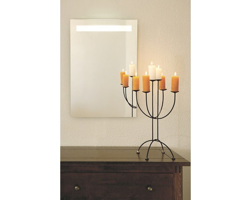 Speglar med belysning och ljusstake på en byrå