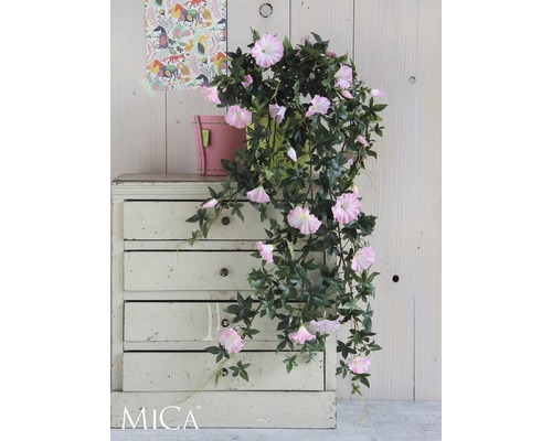 Konstgjord blomman för dagen med rosa blommor i en kruka på ett skåp