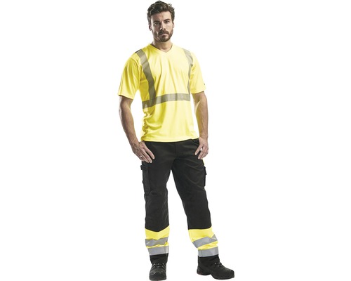 Man som bär en gul varsel-t-shirt och svarta arbetsbyxor