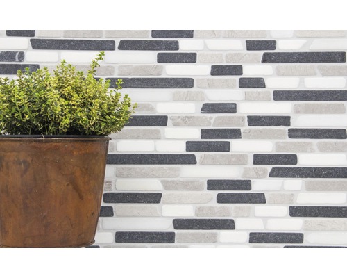 Vägg av mosaikplattor med växt i kruka