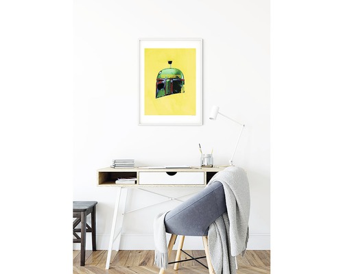 Dekorativ bild med en prisjägares hjälm i ram ovanför ett skrivbord