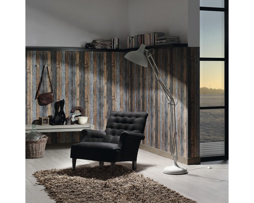 Vardagsrum med fåtölj, golvlampa och väggpaneler i träimitation
