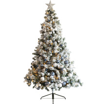 Dekorerad, snötäckt julgran med stjärna och julgranskulor