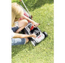 En kvinna byter batteri på en gräsklippare av märket AL-KO.