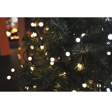 Närbild av en julgran med ljusslinga