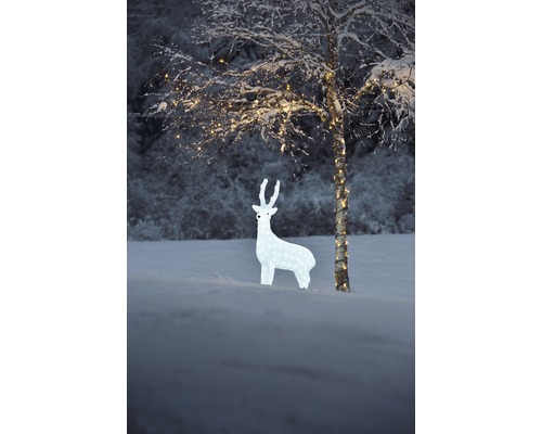 Dekorativ hjort med belysning i snöig trädgård.