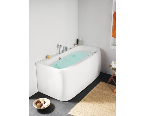 Modernt badrum med fristående badkar, armaturer och badrumstillbehör.