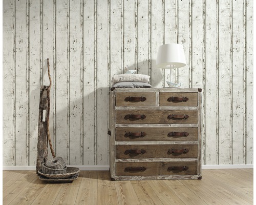 Vardagsrumsscen med träbyrå, lampa, dekoration och tapet i trälook