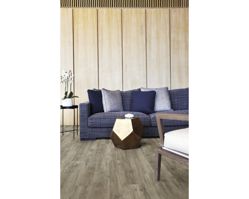 Vardagsrum med soffa, kuddar, bord och golvbeläggning