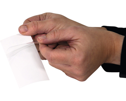 Händer drar bort skyddsfilm från självhäftande film