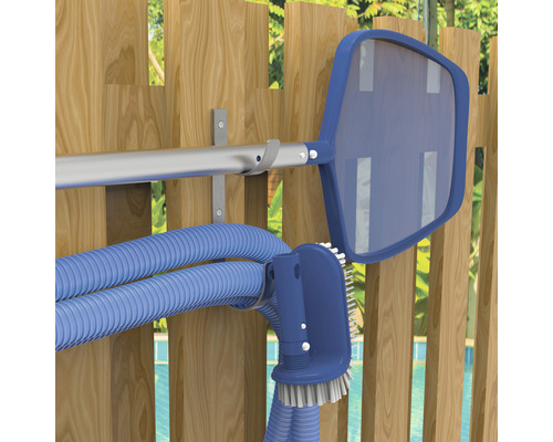Poolrengöringstillbehör på en trävägg, inklusive håv, borste och slang