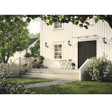 Utsikt över ett hus med träfasad, altan, trädgård och staket.