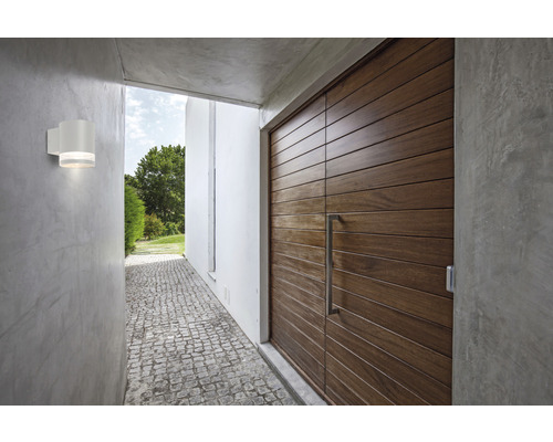 Exteriör med en ytterdörr i trä och en vit vägglampa