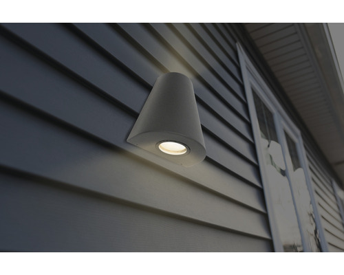 Konformad vägglampa av sten på en husvägg