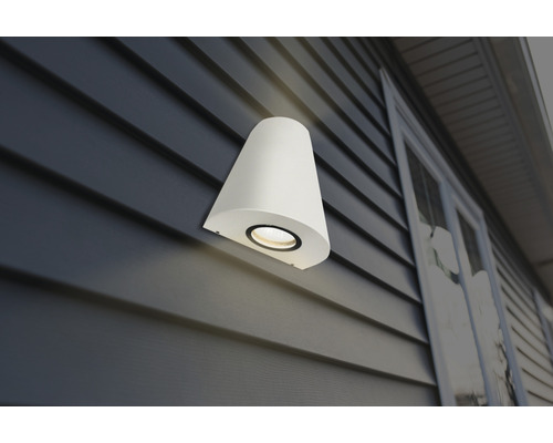 Vit vägglampa för utomhusbruk på en husvägg