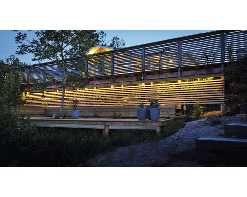 Exteriör av en tvåvåningsbyggnad med träfasad och terrass.