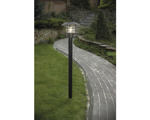 Trädgårdslampa längs en stenlagd stig i en trädgård.