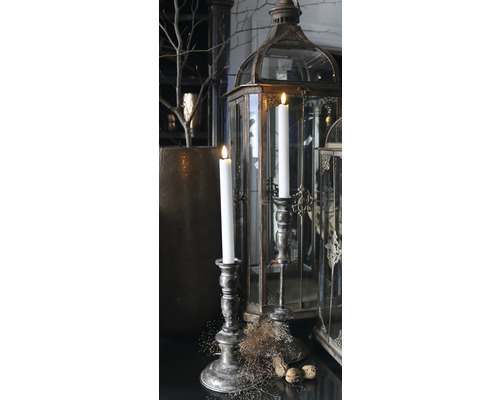 Dekorativt arrangemang med ljus, ljusstakar och lyktor för en stämningsfull atmosfär.