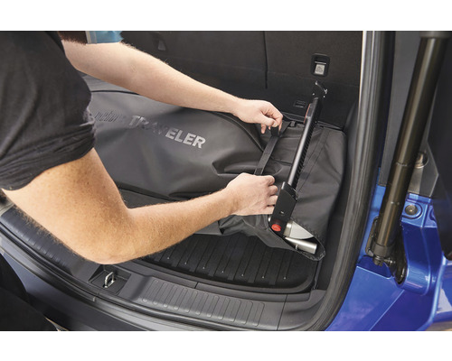 Person som fäster resväska med mobilitetshjälp i bagageutrymmet