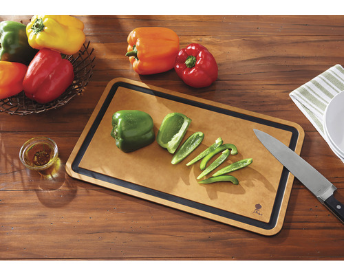 Scen med en skärbräda och knivset bredvid färgglada paprikor