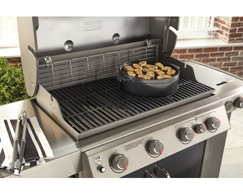 Grill i rostfritt stål med mat på grillplatta och grilltång