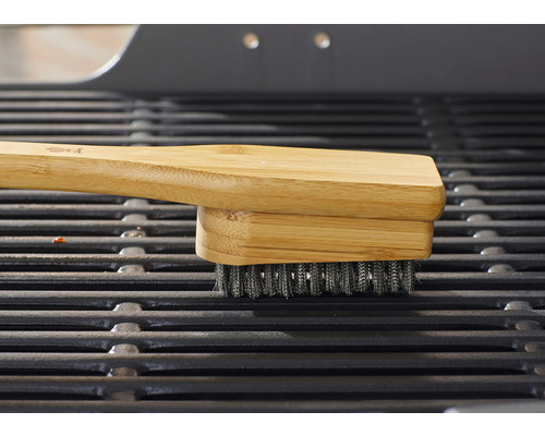 Grillborste med bambuhandtag på ett grillgaller